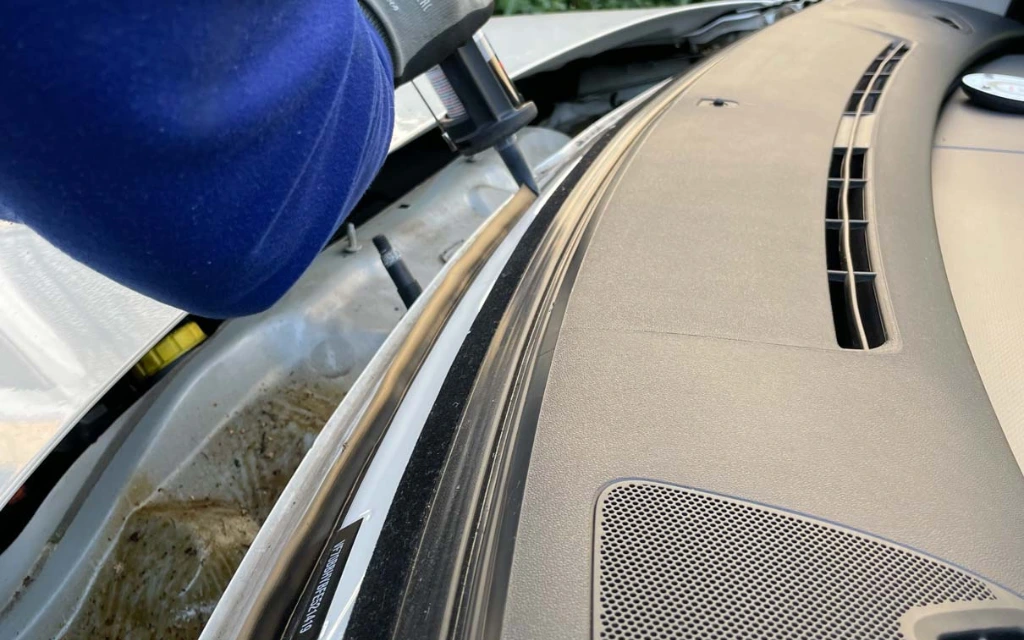Urethane adhesive being applied to a vehicle's pinch weld during windscreen fitting
