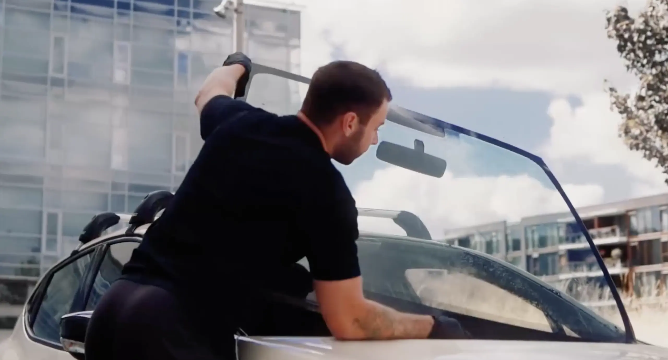 Car glass technician fitting a replacement windscreen