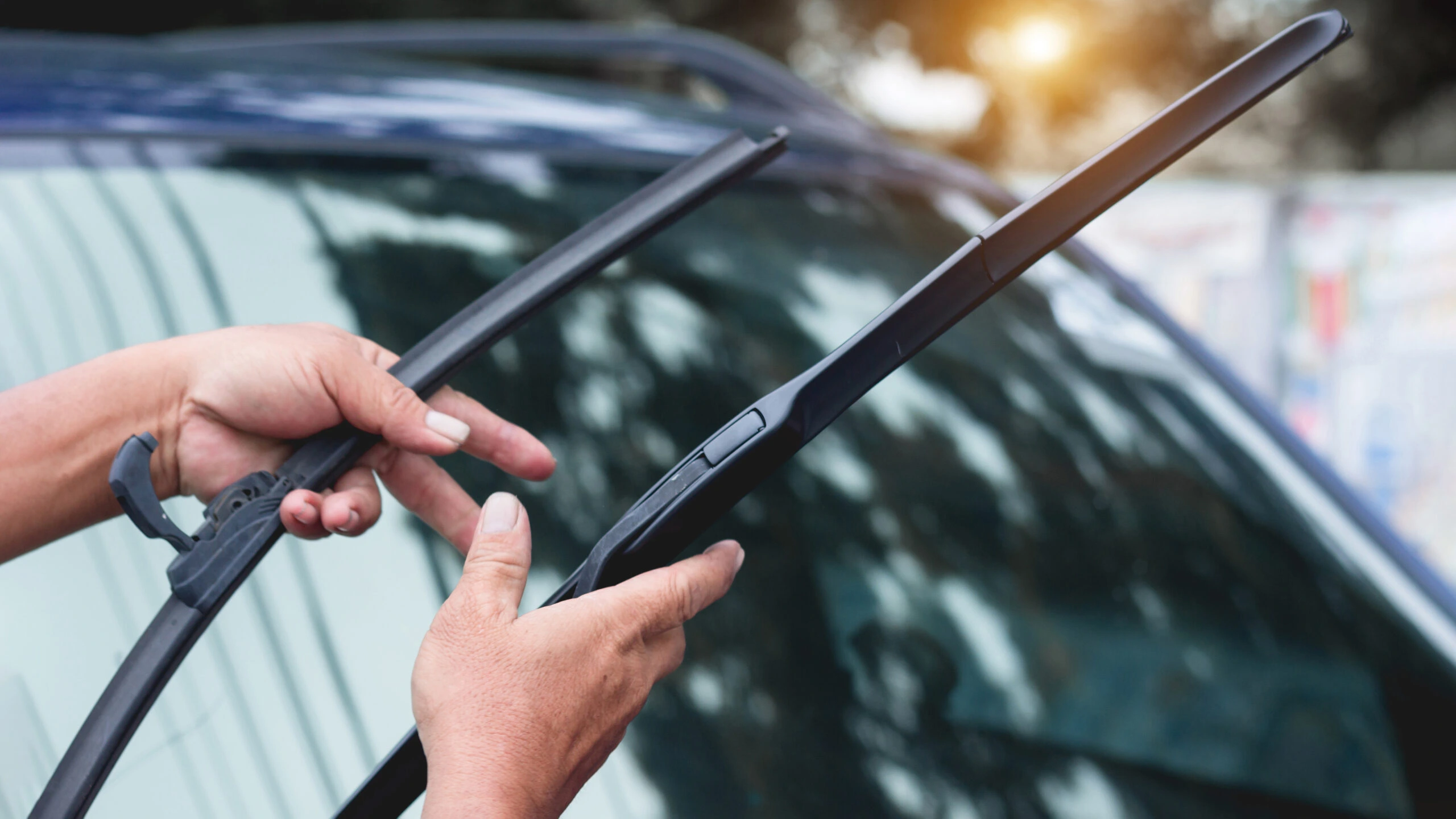 Close-up of car windscreen wiper blades clearing a wet windscreen